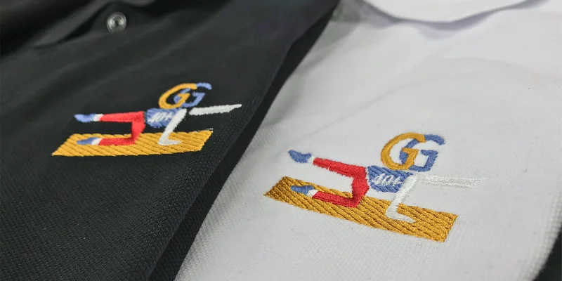 En svart och en vit piké med samma brodyr.