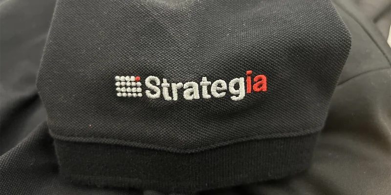 Logotyp broderad på ärmen av en piké.