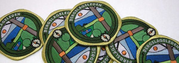 Tygmärken i olika sorter såsom detta helbroderade brodyrmärke gjort med maskinbroderi